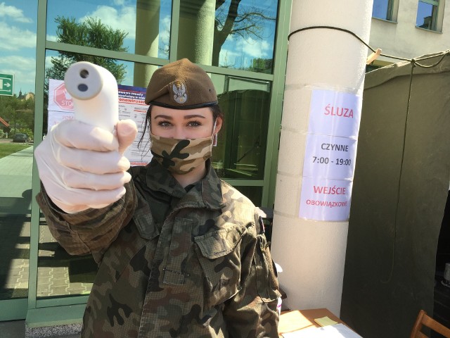 Szeregowa Natalia Ziemacka ze 102. batalionu terytorialsów pod szpitalem w Opatowie ze swoim termometrem. 