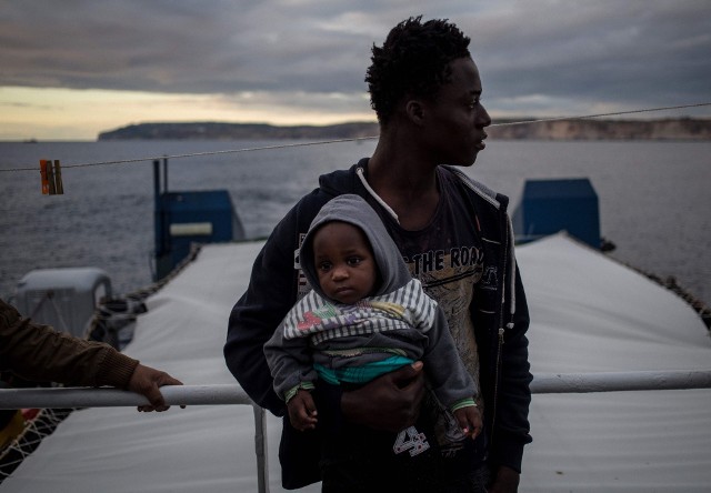 Migrant trzymający dziecko na pokładzie statku Sea Watch 3 AFP/EAST NEWS