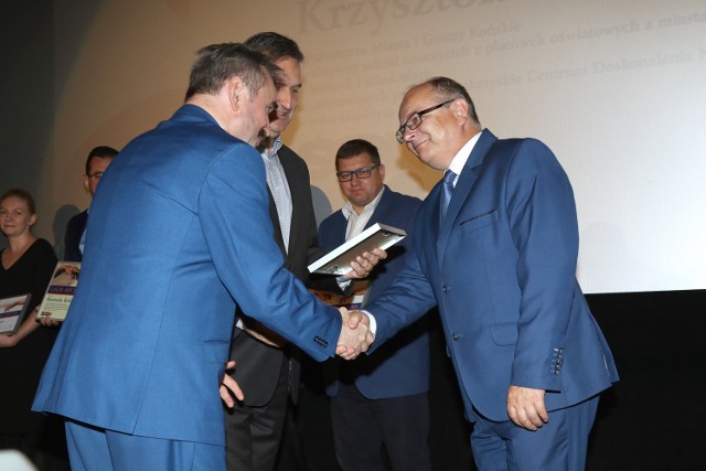 Burmistrz Końskich Krzysztof Obratański odbiera nagrodę z rąk Jacka Wołowca, szefa  Świętokrzyskiego Centrum Doskonalenia Nauczycieli i Jacka Kowalczyka, dyrektora z Urzędu Marszałkowskiego.