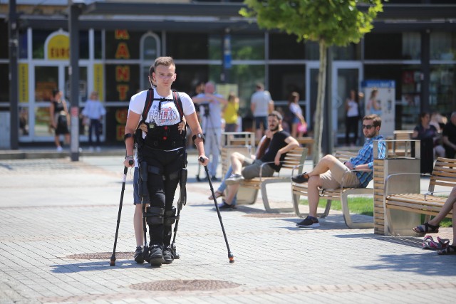 Michał Żołyński kilka lat temu uległ wypadkowi samochodowemu, ma przerwany rdzeń kręgowy i porusza się na wózku inwalidzkim. Stanął na nogi dzięki urządzeniu o nazwie egzoszkielet EKSO GT. W środę spacerował po Rynku w Katowicach.
