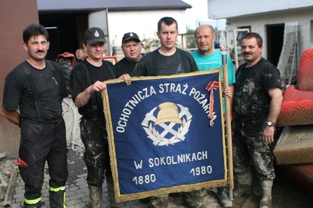 Strażacy ochotnicy z Kuryłówki i Oboźnej prezentują wyczyszczony sztandar Ochotniczej Straży Pożarnej Sokolniki.
