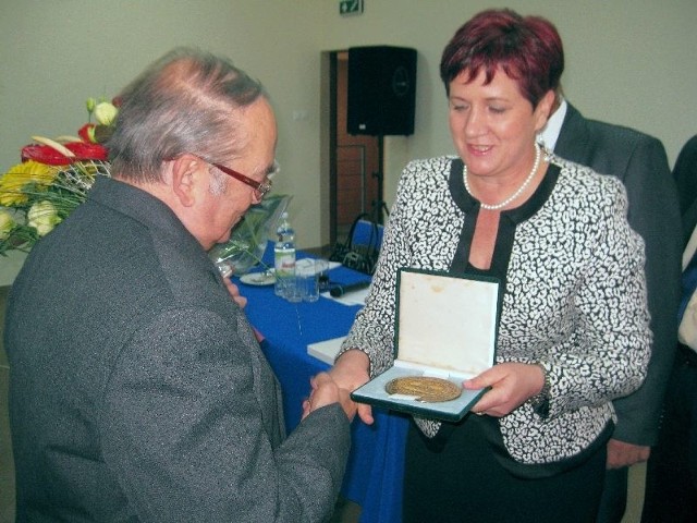 Doktor Andrzej Wąsikowski otrzymuje medal Honorowego Obywatela Gminy Pawłów, z rąk Genowefy Dyk, przewodniczącej Rady Gminy.
