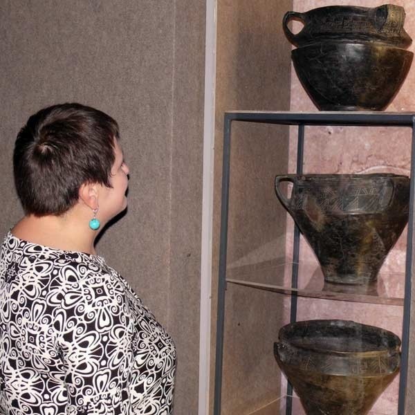 Monika Kuraś przy naczyniach z okresu rzymskiego imperium.