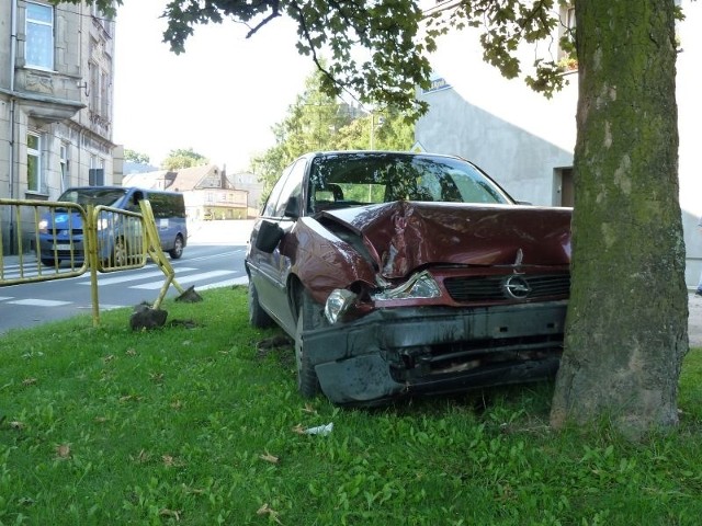 Opel przeciął jezdnię, uszkodził barierki i wylądował na drzewie.