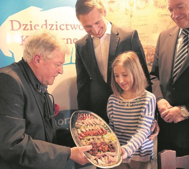 Bolesław Sobolewski proponuje posmakowania jednego z sześciu rodzajów Śledzi po szczecińsku Tosi, córce marszałka