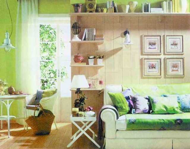 Obrazki z kwiatowymi motywami efektownie zdobią ścianę nad sofą, podkreślając rustykalny charakter pokoju.