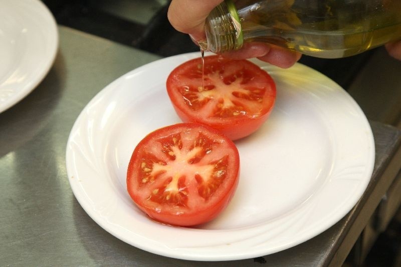 Dokładnie umyte pomidory kroimy na pół, układamy na blaszce...