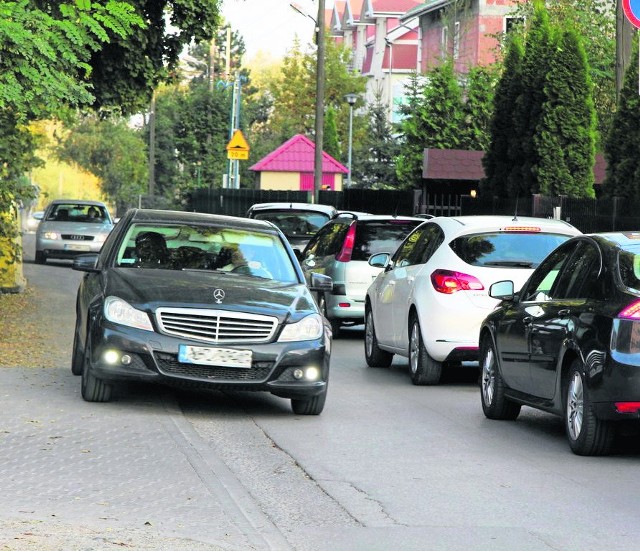 Samochody ledwo się mijają na ul. Lubostroń. Na dodatek część kierowców parkuje wzdłuż drogi. Muszą się też tam zmieścić piesi.