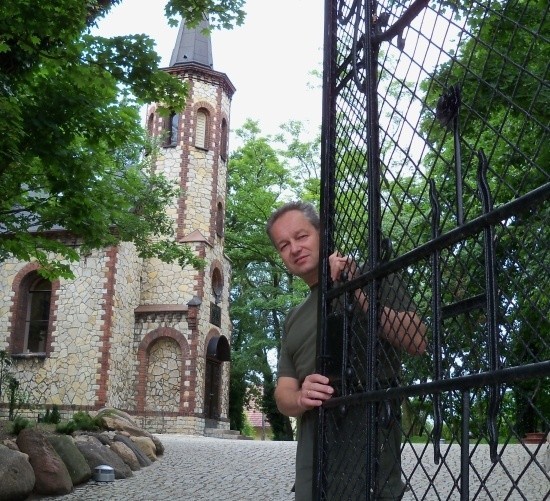Norbert Siekierka przed wyremontowanym kościółkiem.