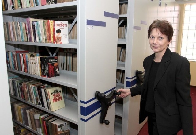 Alicja Wilczyńska, pracownik Biblioteki Publicznej, prezentuje nowoczesne, przesuwne regały. Mimo, że wyglądają na ciężkie, ich obsługa jest bardzo prosta, a mechanizm przesuwa się bardzo lekko.