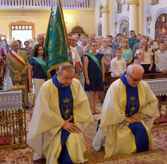 Księża Ryszard Witek i Zbigniew Stanios wprowadzają sztandary ludowców na mszę świętą w sanktuaryjnym kościele.