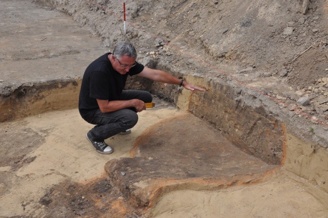 Archeolog doktor Marek Florek pokazuje ślady po wczesnośredniowiecznych paleniskach.