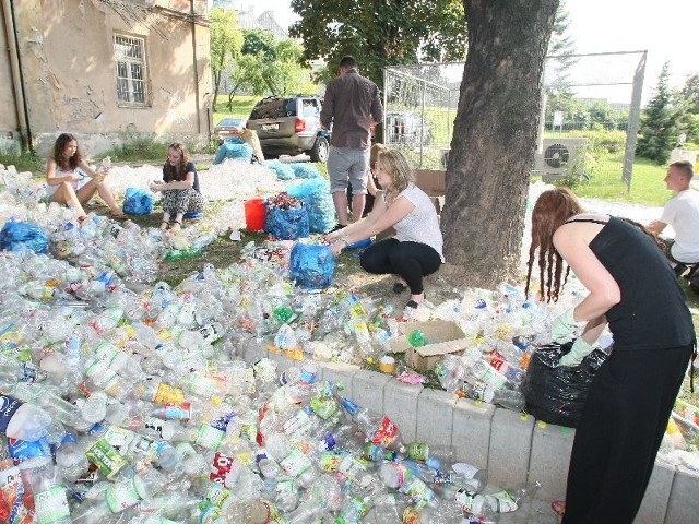 Wolontariusze pomagają czyścić butelki.