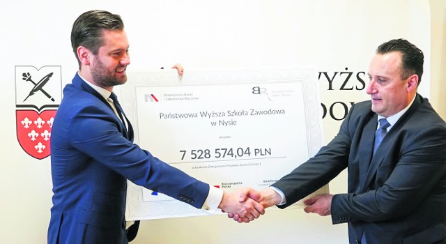 Kamil Bortniczuk (po lewej), doradca ministra nauki, przekazał symboliczny czek rektorowi Przemysławowi Malinowskiemu.