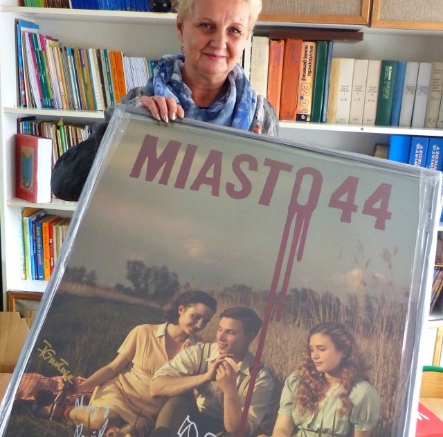 Izabela Działak, dyrektor Szkoły Podstawowej numer 3 w Suchedniowie prezentuje plakat z filmu Miasto 44 z autografami aktorów.
