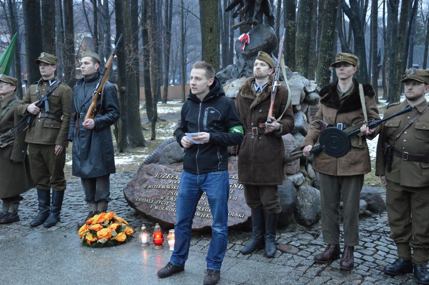 Ks. Jacek Międlar przed pomnikiem Józefa Kurasia "Ognia" w...