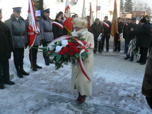 Pod pomnikiem Stefana Gądzio "Kosa&#8221; złożono kwiaty. Na zdjęciu wiązankę niesie Renata Kawiorska, sekretarz Urzędu Miejskiego w Jędrzejowie.