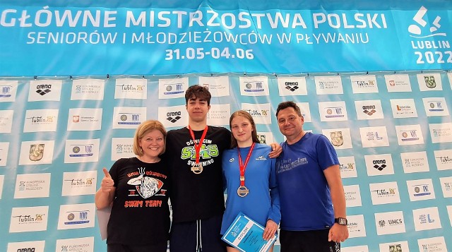 Michał Piela i Zuzanna Famulok, mistrzowie Polski na 400 metrów stylem zmiennym na długim basenie z trenerami; Alicją Woźnicką (pierwsza z lewej) i Andrzejem Branią (pierwszy z prawej).