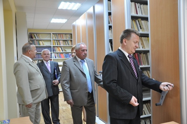 Burmistrz Chęcin Robert Jaworski (na zdjęciu pierwszy z prawej) oraz starosta kielecki Zenon Janus (na zdjęciu drugi z prawej) przy regałach nowej biblioteki w Chęcinach.