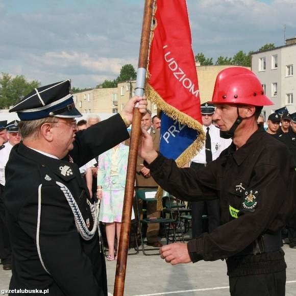 Prezes lubuskich strażaków-ochotników Edward Fedko (z lewej) przekazuje sztandar naczelnikowi jednostki Krzysztofowi Hacasiowi.