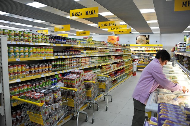 W supermarkecie trwają przygotowania na przyjęcie klientów – produkty ustawiane są na półkach 