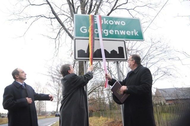 tablicę w Bukowie odsłaniają (od lewej): Rudolf Lawa (przewodniczący gminnego zarządu TSKN, Bernard Gaida (przewodniczący VdG) i wójt Murowa Andrzej Puławski.
