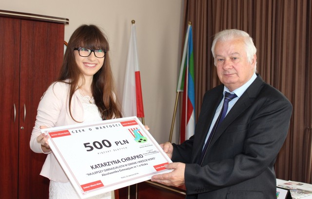 Burmistrz Niska Julian Ozimek wręcza Katarzynie Chrapko symboliczny czek na 500 złotych za wspaniałe wyniki w nauce w gimnazjum