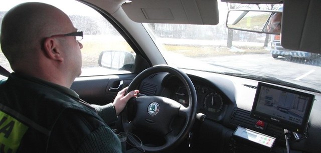 Inspektor Sebastian Kuryś z Inspekcji Transportu Drogowego za kierownicą wozu uzbrojonego w dwie kamery.
