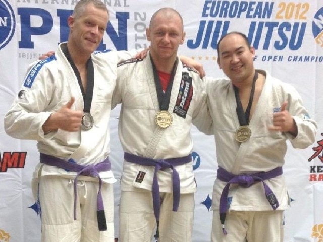 Paweł Kunysz - w środku, na najwyższym stopniu podium w zawodach London International Brasilian Jiu Jitsu Open 2012, gdzie zdobył złoty medal w kategorii "purpurowych pasów&#8221;.