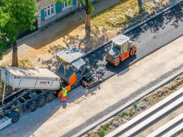 Układanie pierwszej warstwy asfaltu na nowej jezdni ul. Śmigłego - Rydza.