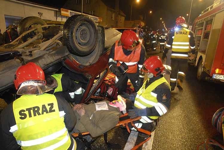 Wraki samochodów , pedzące na sygnale wozy strazaków i...