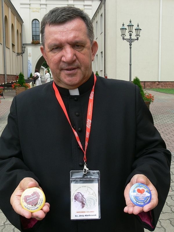 Kierownik skarżyskiej pielgrzymki, ksiądz Jerzy Karbownik, prezentuje odznaki &#8222;Przyjaciel Pielgrzyma&#8221;, które pątnicy będą wręczać gospodarzom, przyjmującym ich na nocleg. 