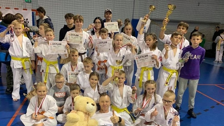 Młodzi karatecy z medalami i sensei Piotrem Kęćką.