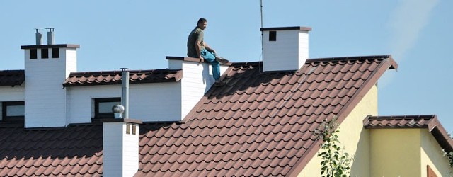 Mieszkaniec Tarnobrzega-Wielowsi nerwowo spogląda na wodę z dachu swojego domu.