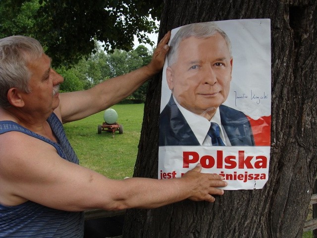 Tadeusz Kubiszyn poprawia plakat Jarosława Kaczyńskiego, koło swojego domu. - Nikt go nie zerwał - zaznacza. - To był tylko wiatr.