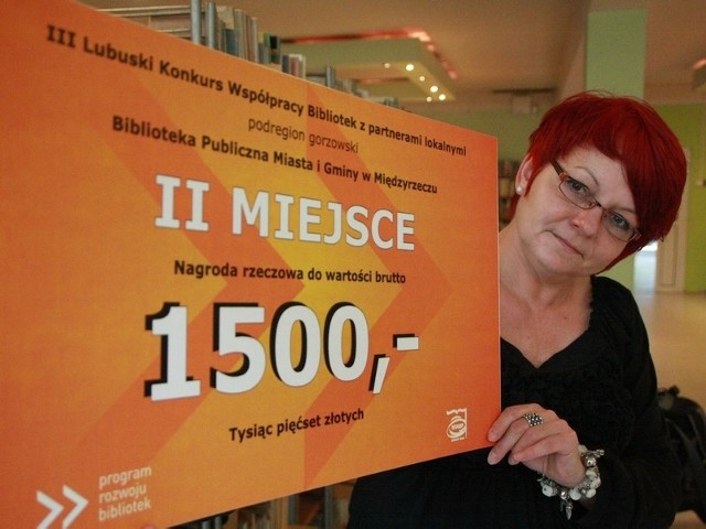 Dyrektorka biblioteki Krystyna Pawłowska z duma prezentuje symboliczny czek na 1,5 tys. zł.