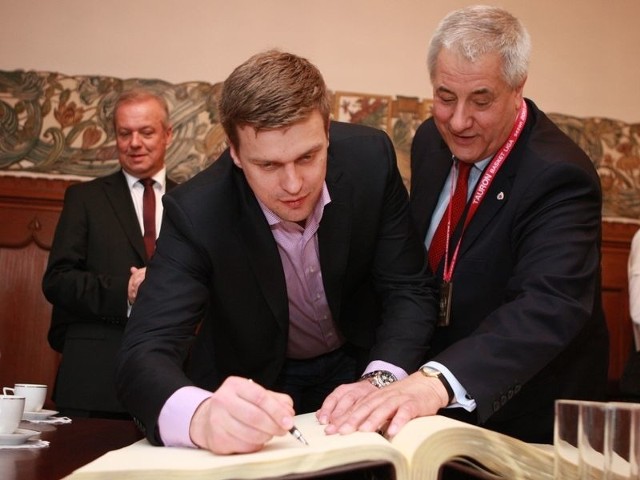 Adomaitis podpisuje... nie, jeszcze nie nowy kontrakt. To wpis do księgi pamiątkowej Słupska. Z prawej prezydent miasta Maciej Kobyliński.