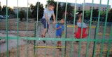 Dzieci skaczą przez płot by zabić nudę i dostać się na plac zabaw