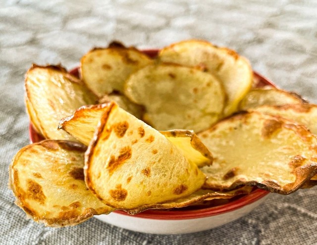Macie ochotę na tanią przekąskę z ziemniaków? Zobaczcie nasze propozycje na małe co nieco z kartofli. Na zdjęciu domowe czipsy ziemniaczane.