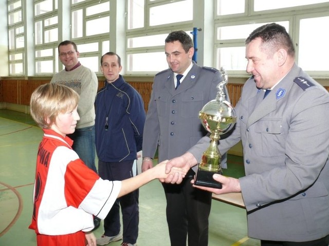 Adam Cichoń, kierownik posterunku policji w Sobkowie (z prawej) oraz dzielnicowy Łukasz Rutowicz (drugi z prawej) wręczają zwycięzcą puchary.