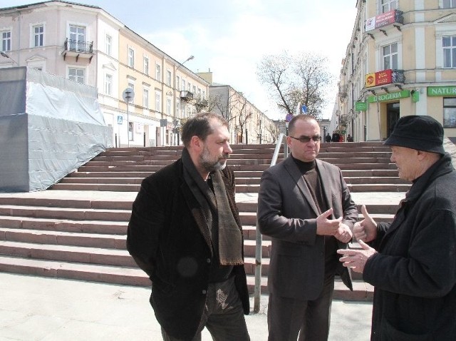 Paweł Pietrusiński, Janusz Koza i profesor Gustaw Zemła rozmawiają pod makietą cokołu pomnika marszałka Józefa Piłsudskiego na Placu Wolności.