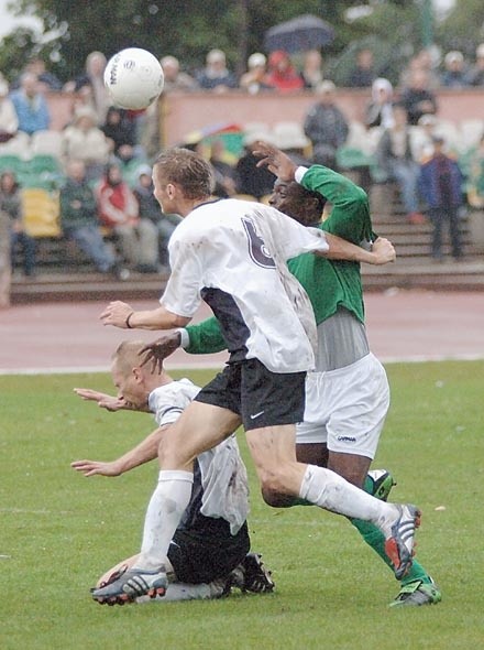Jacek Kocur (z Arki, nr 6), walczy o piłkę z zielonogórskim Nigeryjczykiem Enyinnay'ą. Z lewej Wojciech Winograd z Arki.