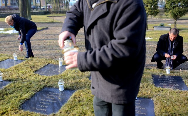 Delegacja z chojnickiego ratusza zapala znicze na cmentarzu żołnierzy radzieckich.