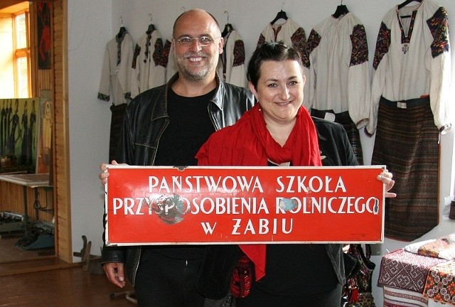 Gabriela i Uwe Seltmannowie w Żabiem z tablicą przedwojennej polskiej szkoły w tej miejscowości.