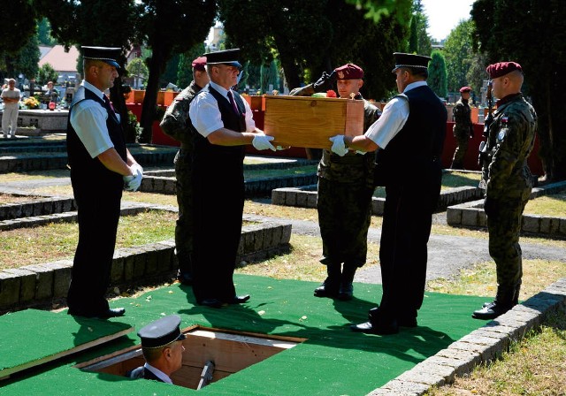 Trumny ze szczątkami czerwonoarmistów do zbiorowej mogiły przenosili żołnierze Wojska Polskiego