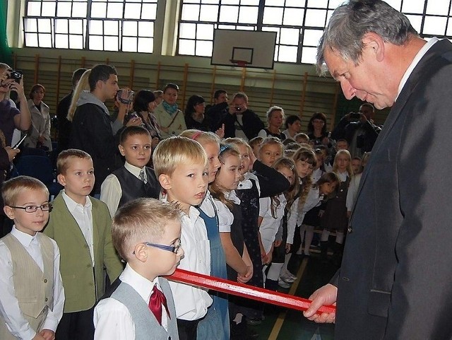 Tomasz Wysocki dotykał wielkim ołówkiem ramienia pierwszoklasistów  i pasował na ucznia szkoły.