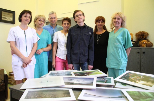 Przemysław Wolak, ordynator oddziału chirurgicznego szpitala dziecięcego w Kielcach razem z pielęgniarkami oglądają fotografie, jakie podarował na rzecz oddziału  17 letni pacjent Dominik Pocheć za uratowanie mu życia.