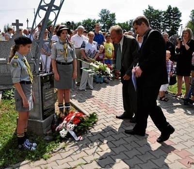 Grzegorz Kulesza ze swoim tatą składają kwiaty przy tablicy upamiętniającej partyzantów Fot. Jarosław Boruczkowski