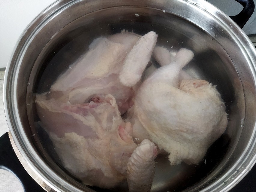 Pokrój kurczaka na części i zalej zimną wodą ok. 3 l.