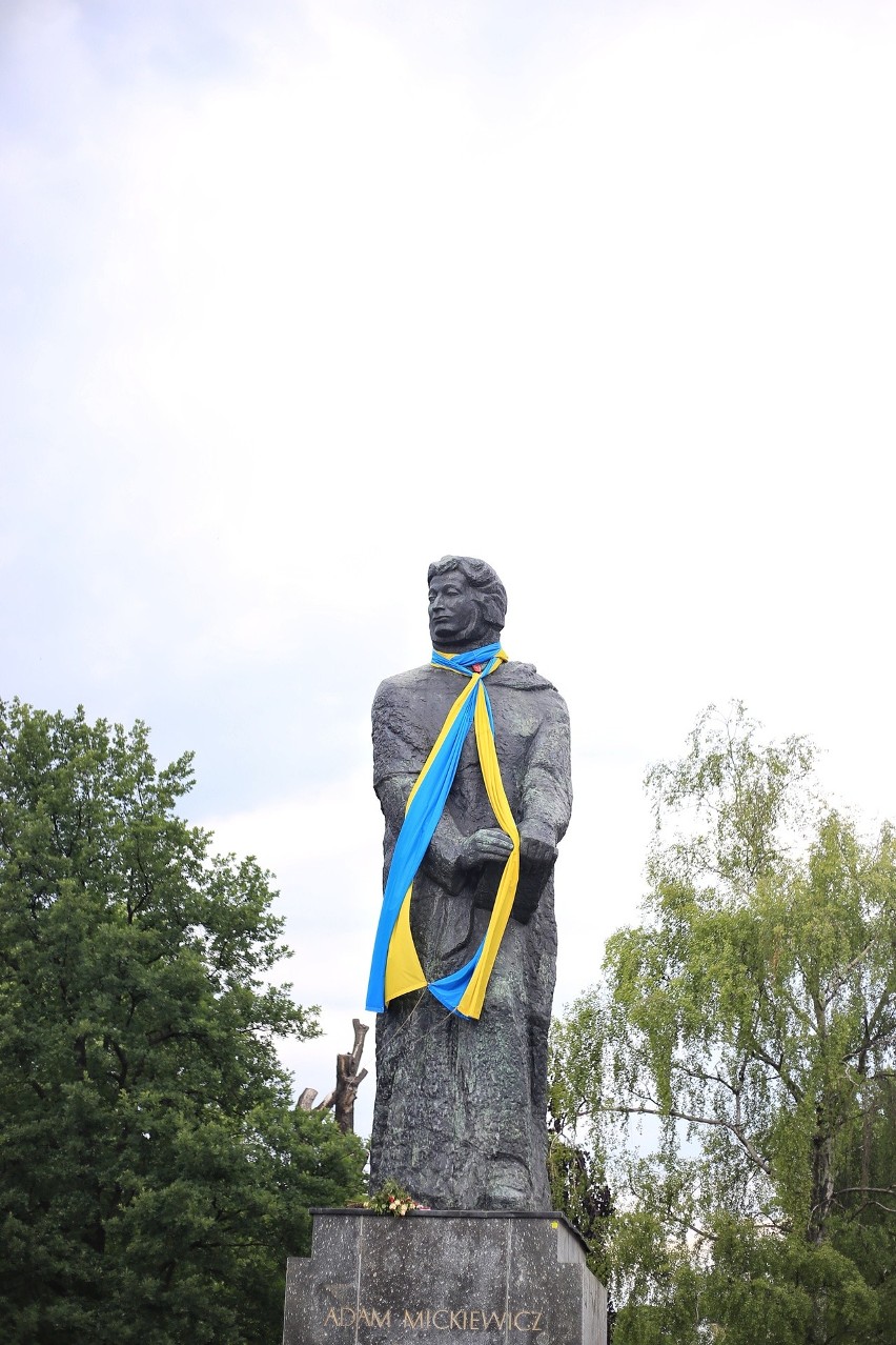 Na pomniku Adama Mickiewicza wisi duża niebiesko-żółta...